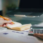 what is EMI — person calculating monthly loan installment with calculator and notebook