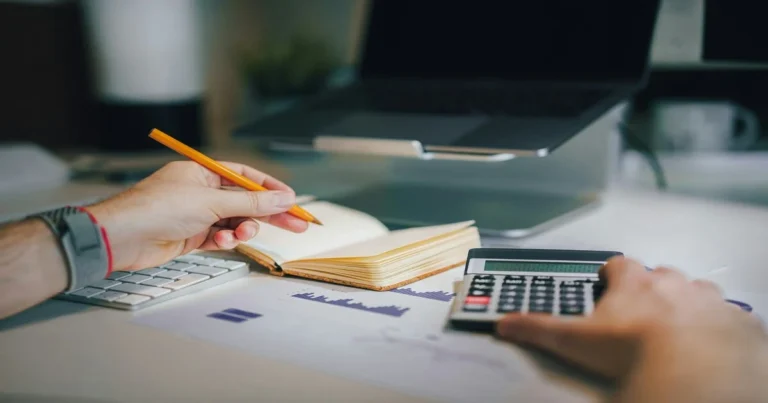 what is EMI — person calculating monthly loan installment with calculator and notebook